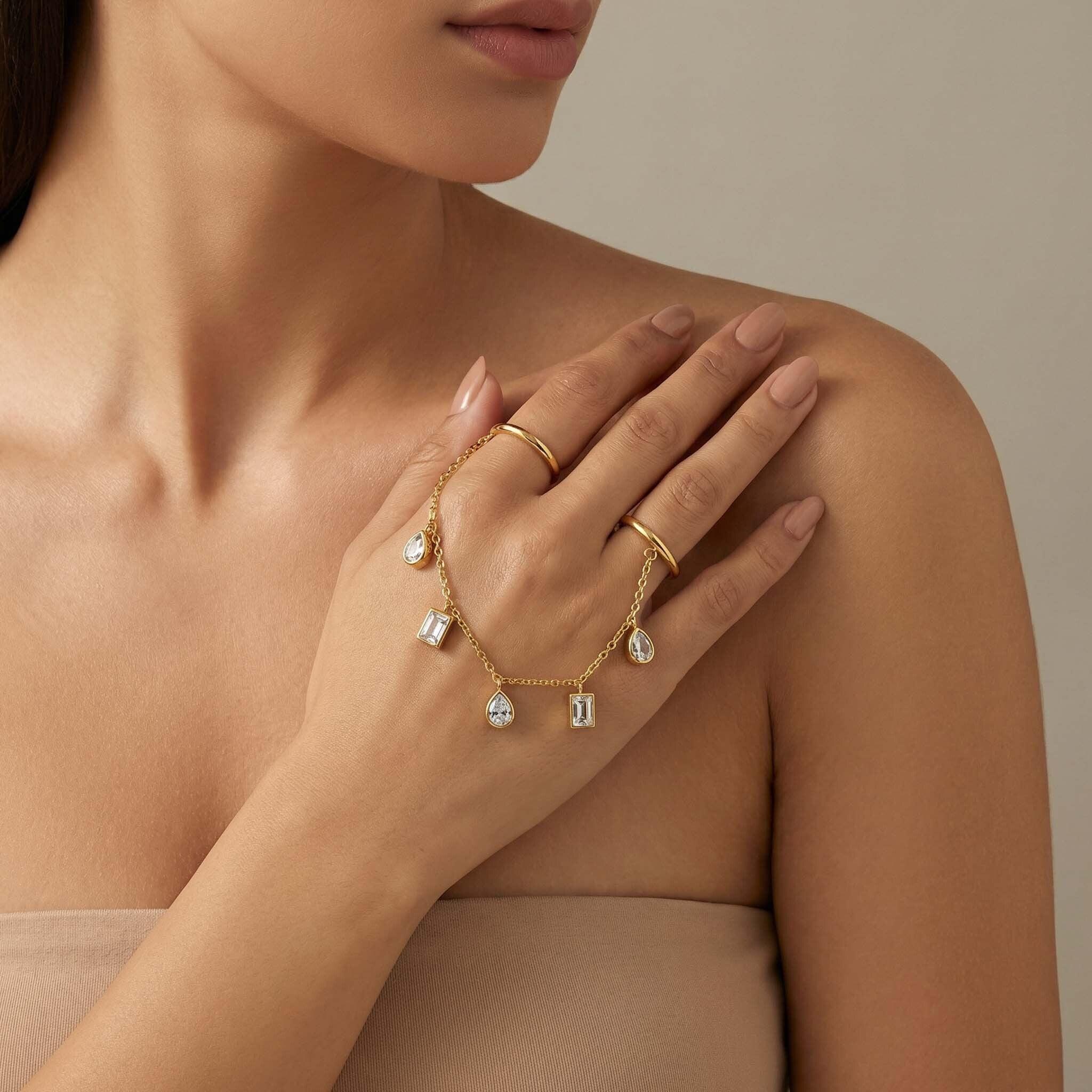 Close-up of a person wearing gold jewelry with a neutral background