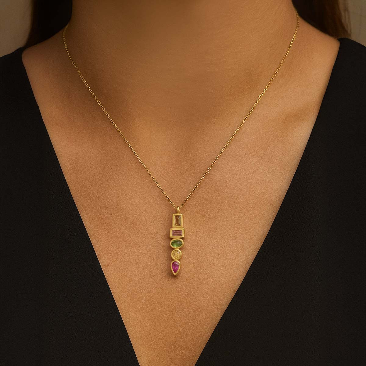 Gold necklace with pink, white, and purple gemstone accents