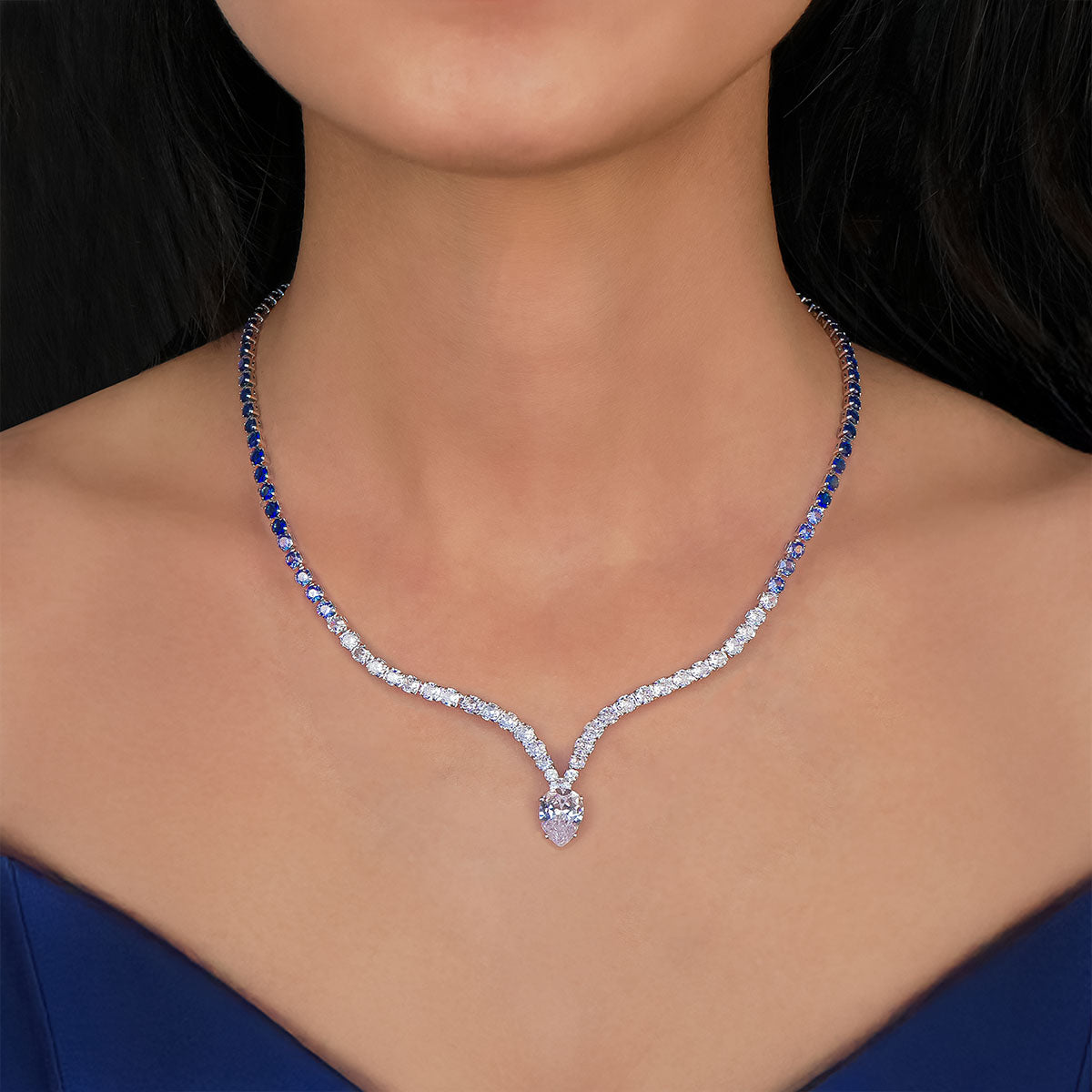 Diamond necklace with blue gemstones on a model wearing a blue dress