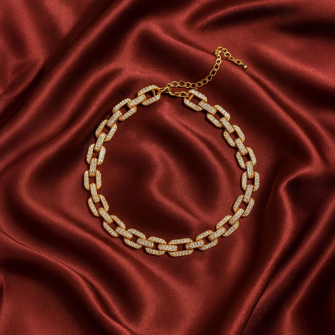 Gold chain necklace for women on a red satin background