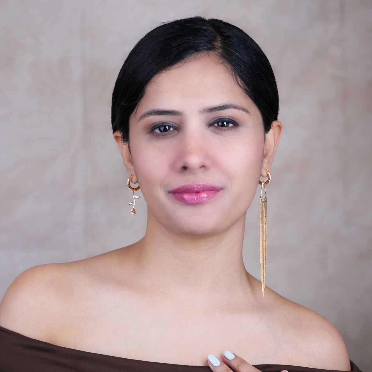 Woman wearing gold earrings for women against a neutral background