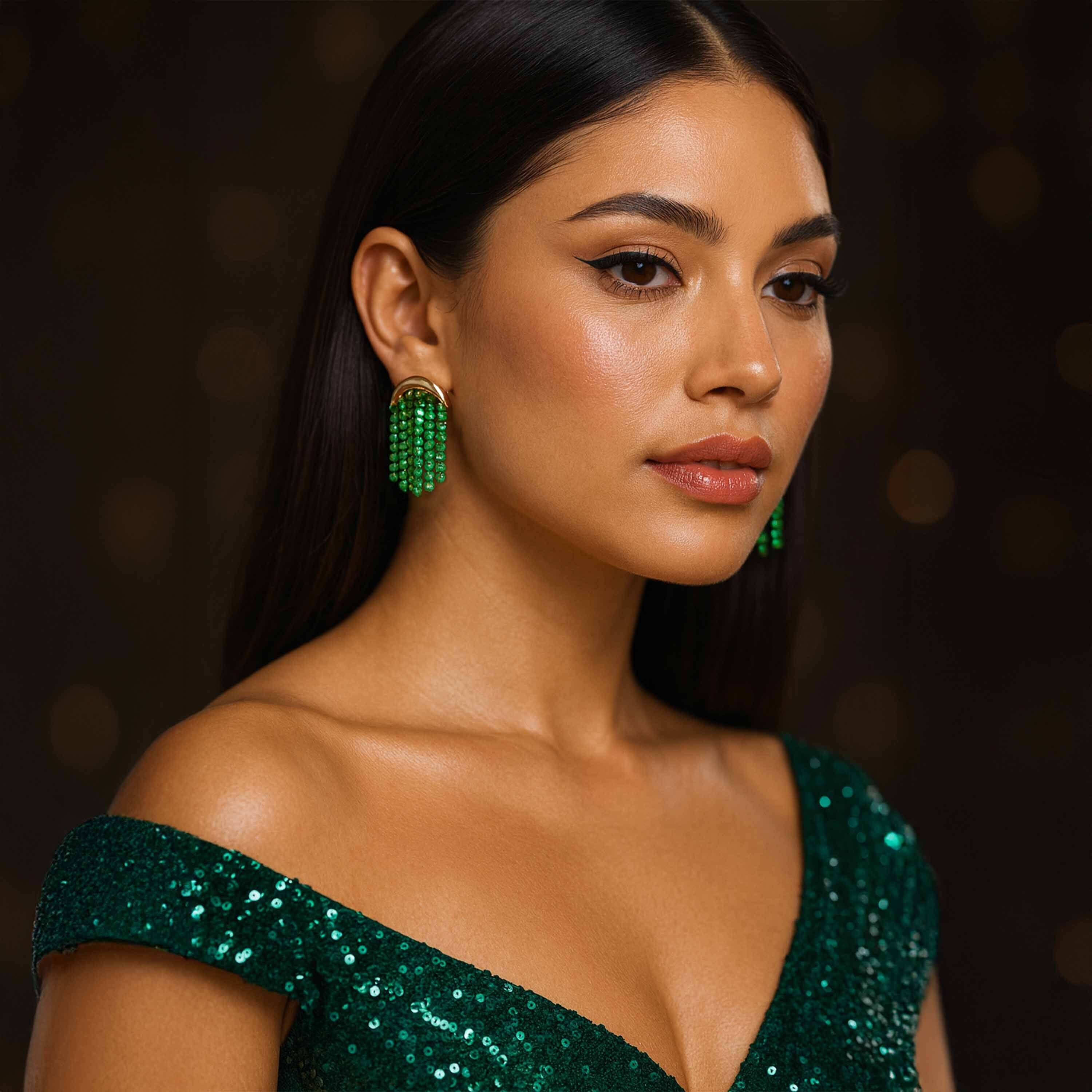 Woman wearing green sequin top and earrings against a dark background