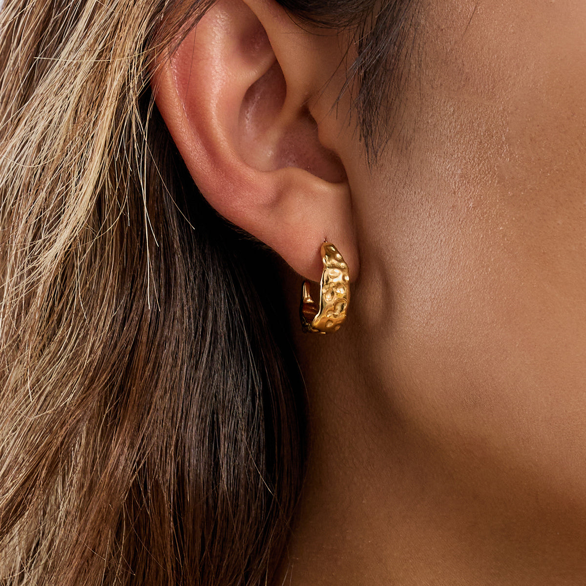 Close-up of a person wearing a gold hoop earring for women daily wear use