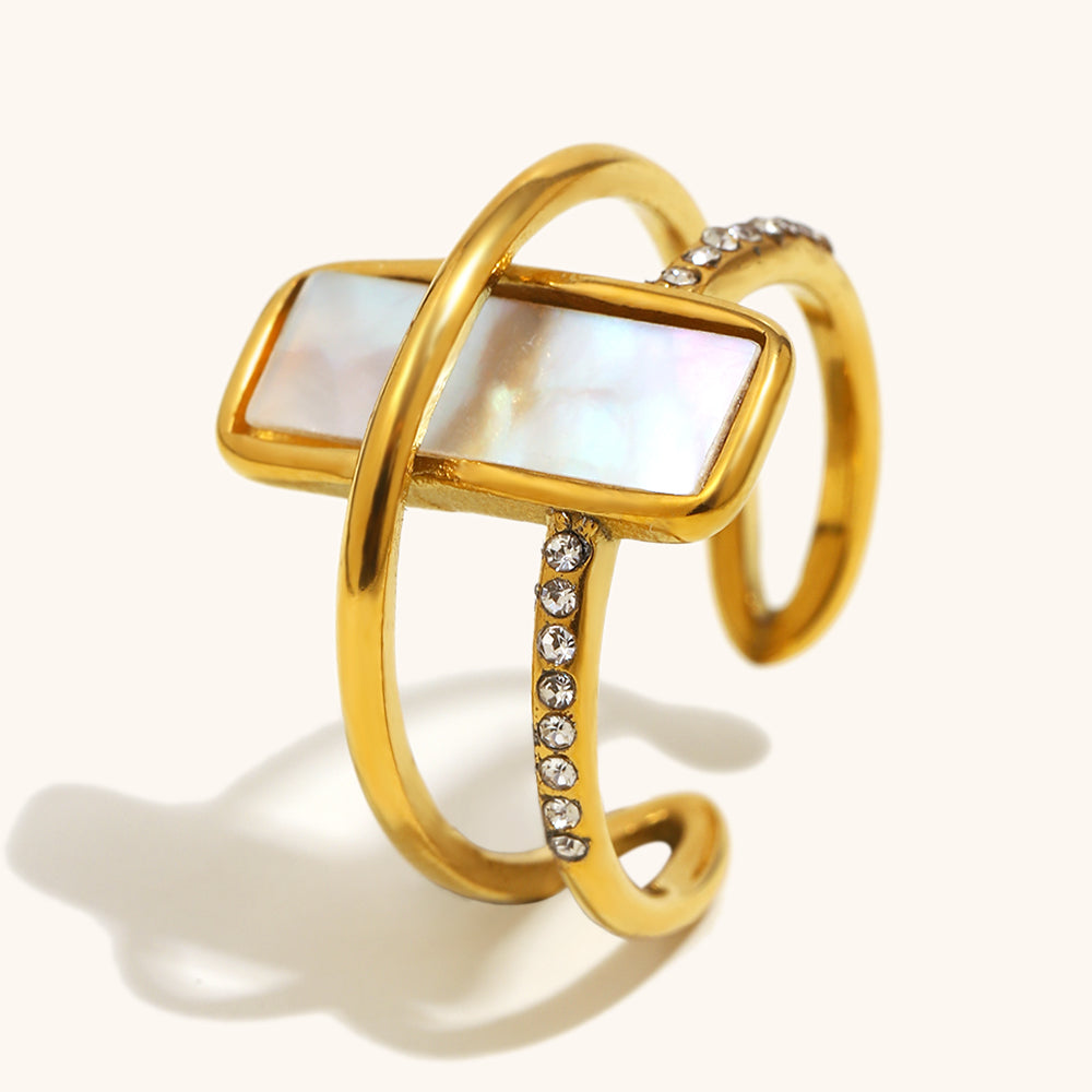 Gold ring with a rectangular gemstone and diamond accents on a white background