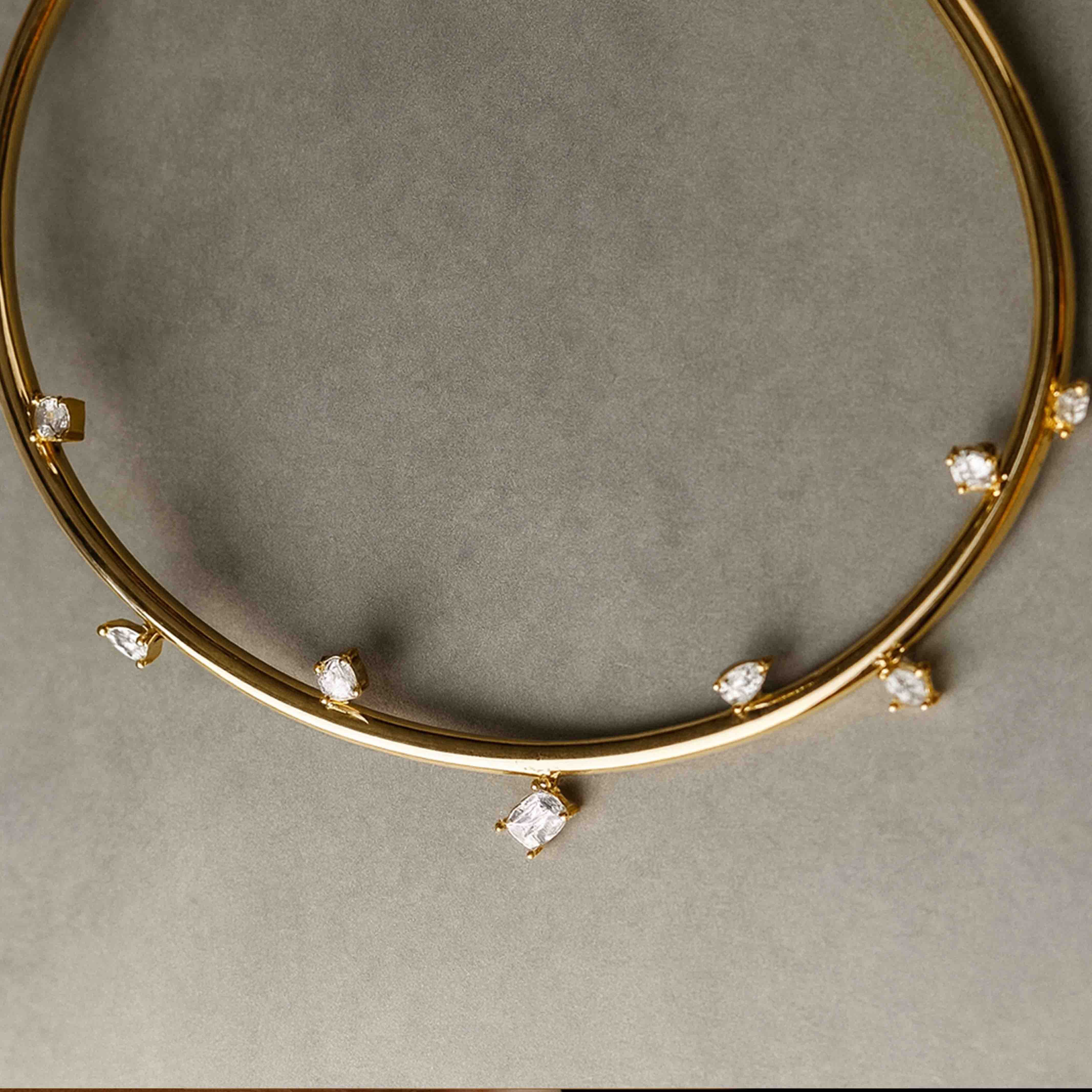 Gold necklace with small diamonds on a gray background