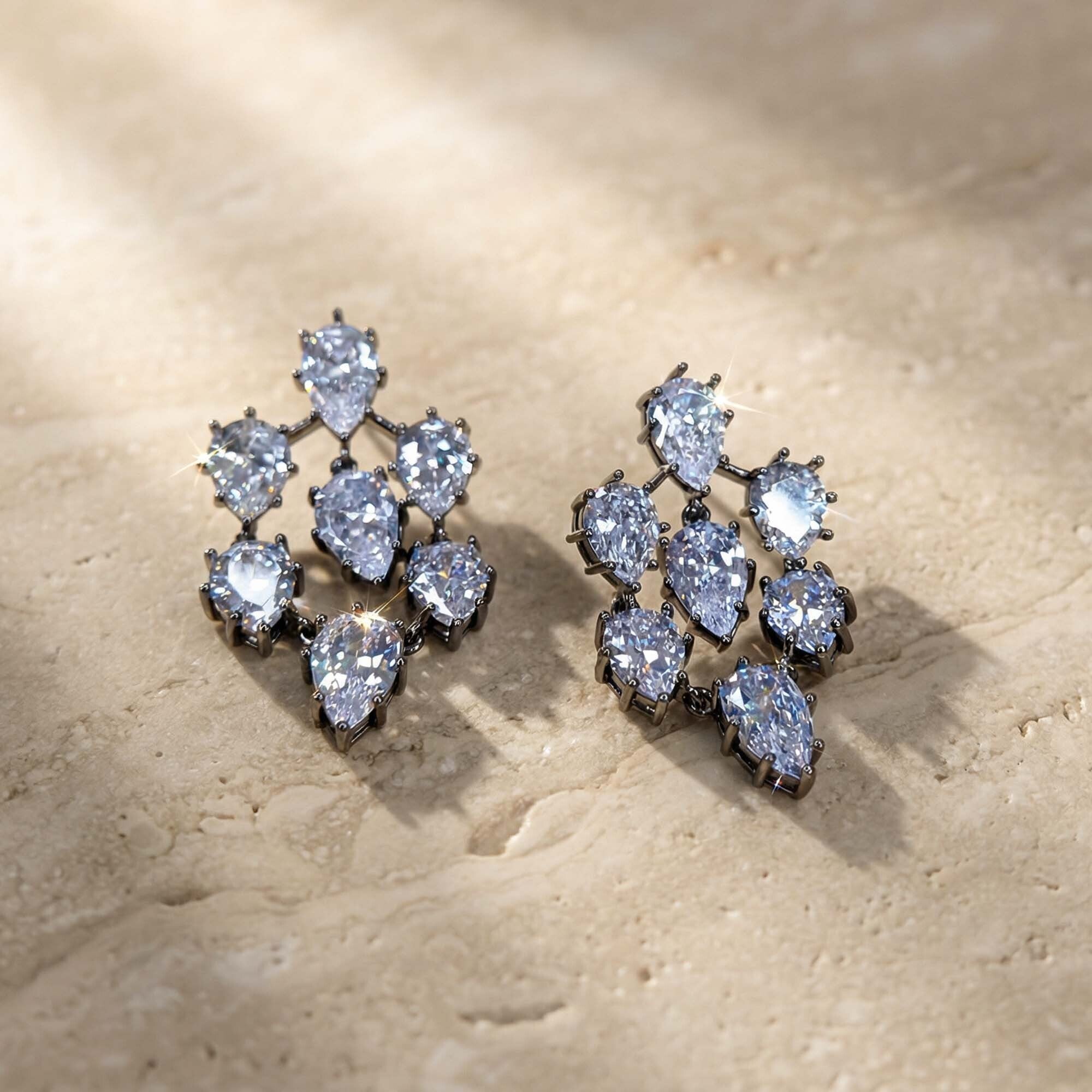 Pair of diamond earrings for women on a beige stone surface