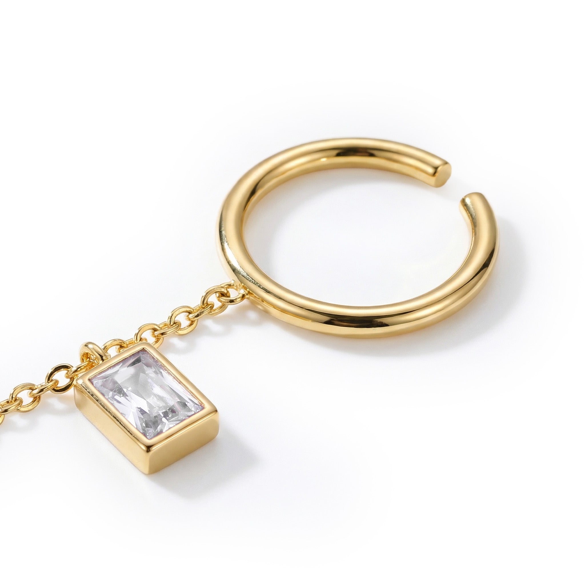 Gold ring with a rectangular gemstone on a white background
