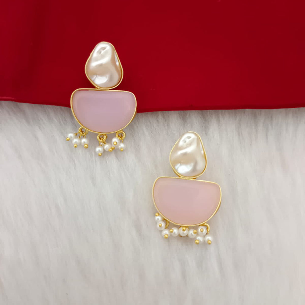 Pair of earrings with pink stones and pearl-like beads on a red and white background