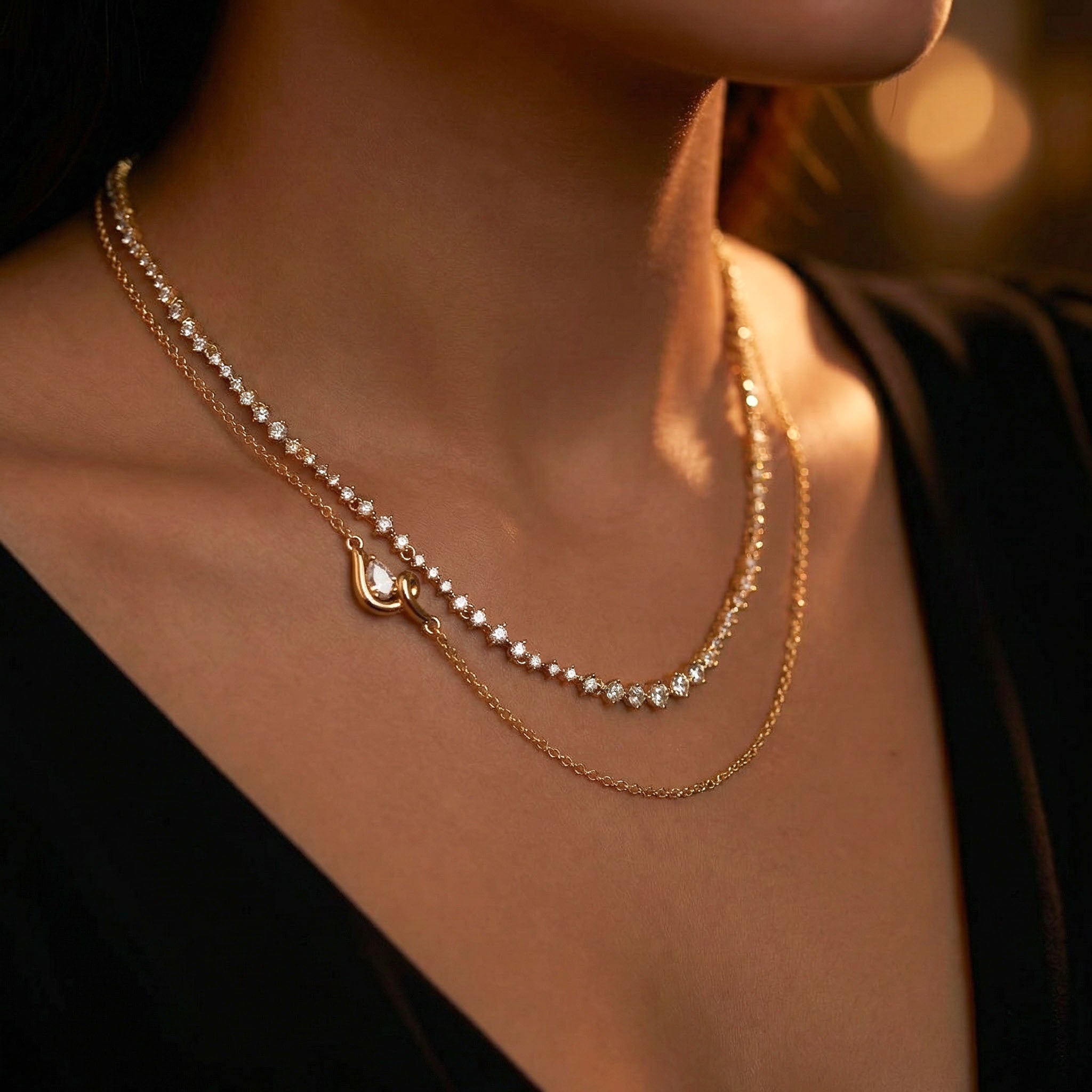 Close-up of a person wearing a gold necklace with a blurred background