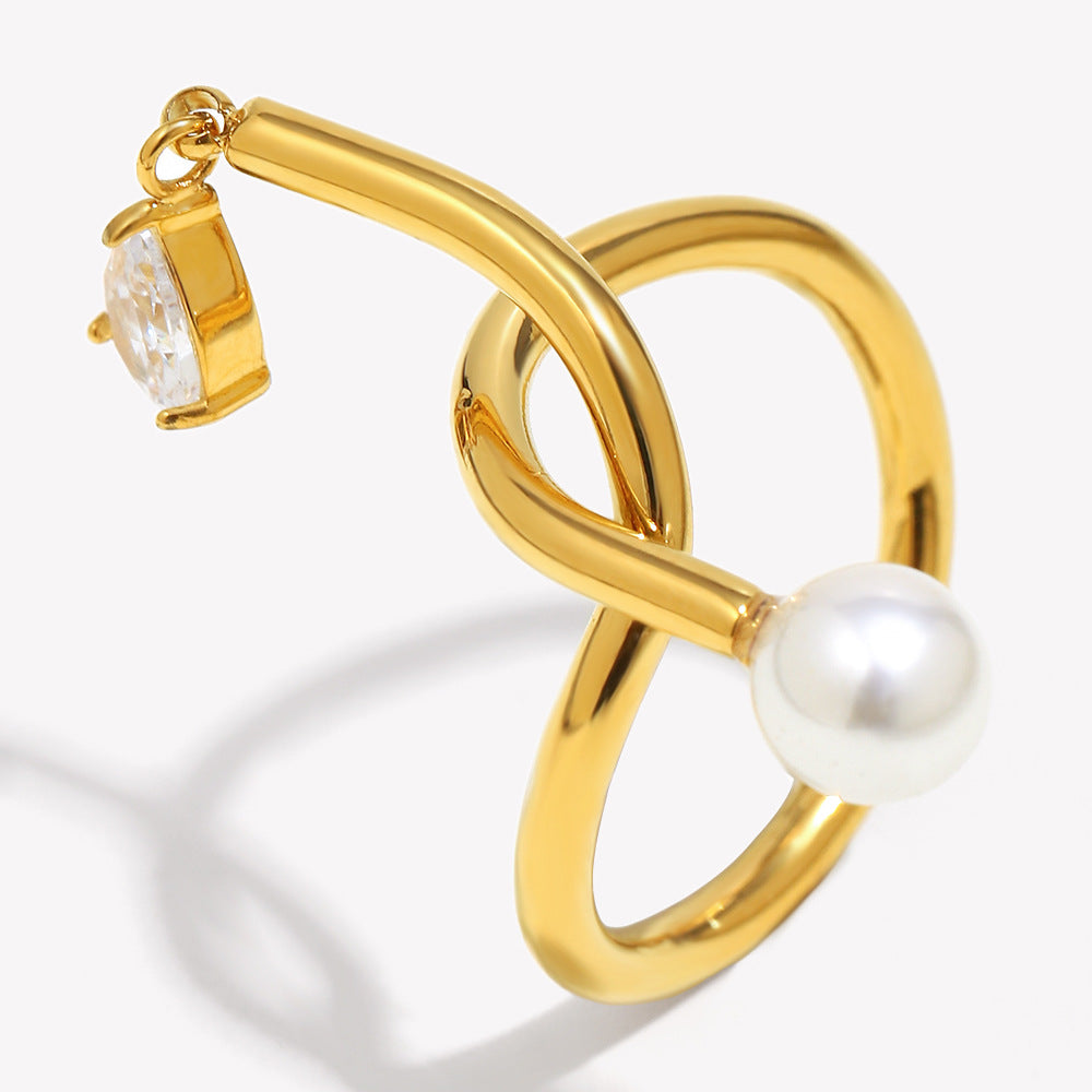 Gold earring with a pearl and clear gemstone on a white background