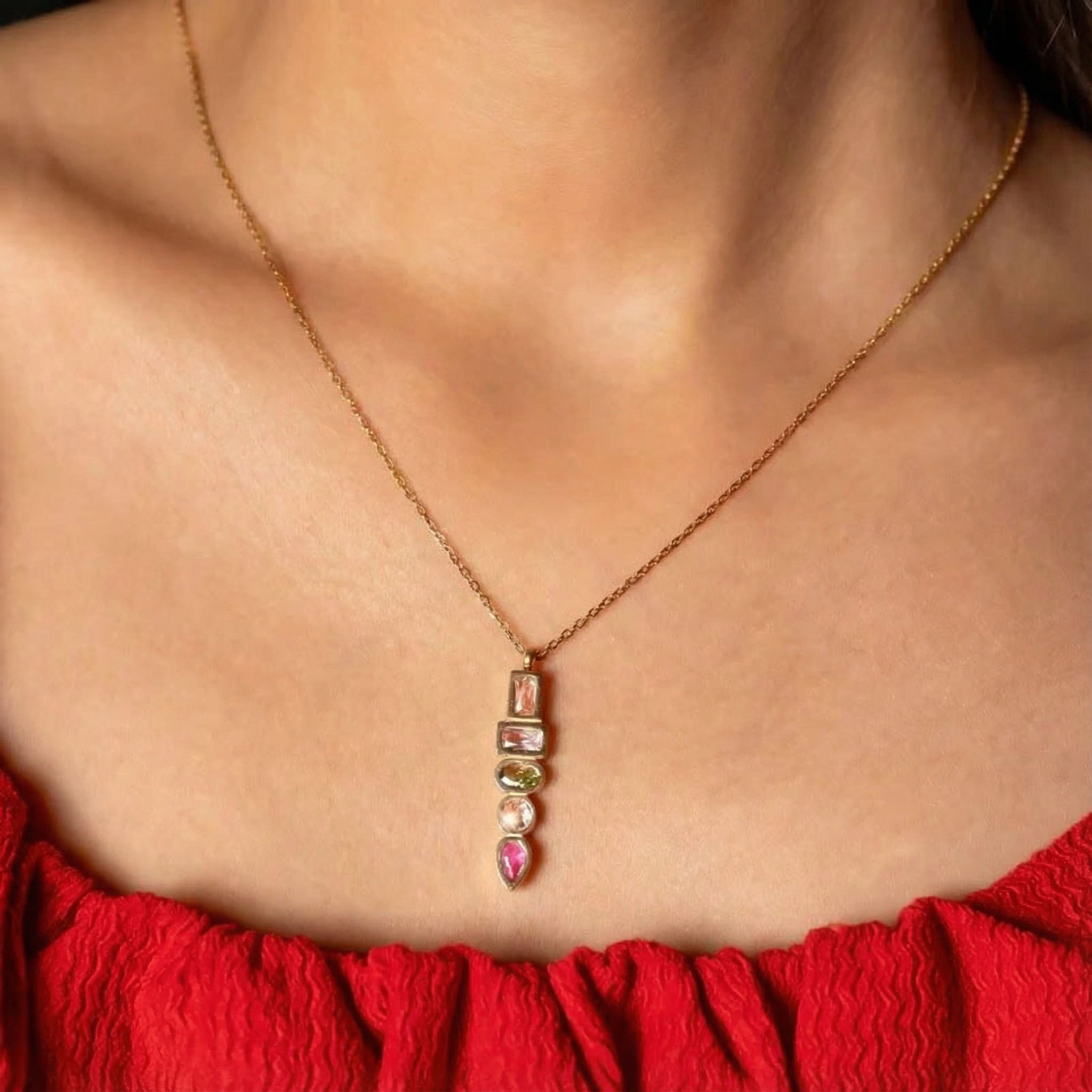 Gold pendant necklace for women with stacked pink and green crystal stones, modern statement necklace close-up