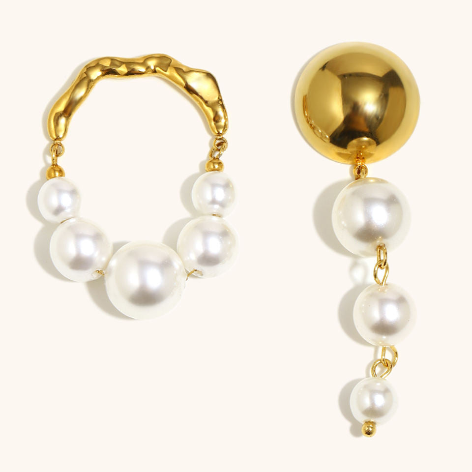 Gold hoop earrings with pearl drops on a white background