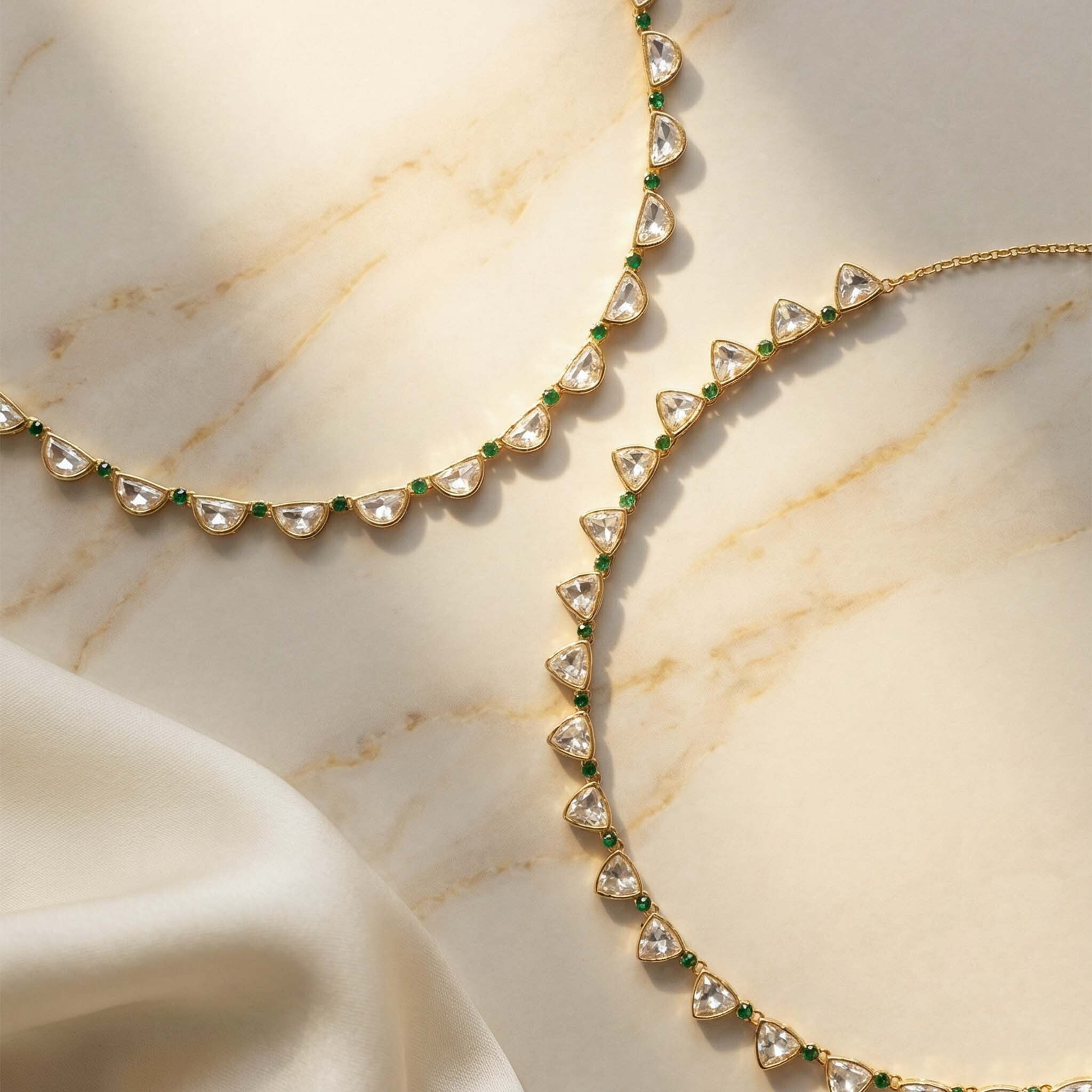 Gold necklace with gemstones on a marble surface