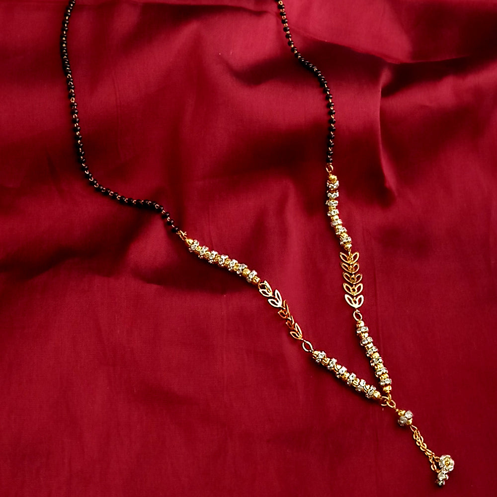 Gold necklace with black beads on a red fabric background