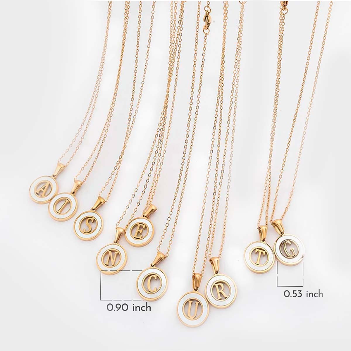 Gold necklaces with circular pendants displaying letters on a white background