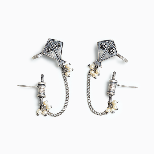 Pair of silver kite-shaped earrings with pearl accents on a white background