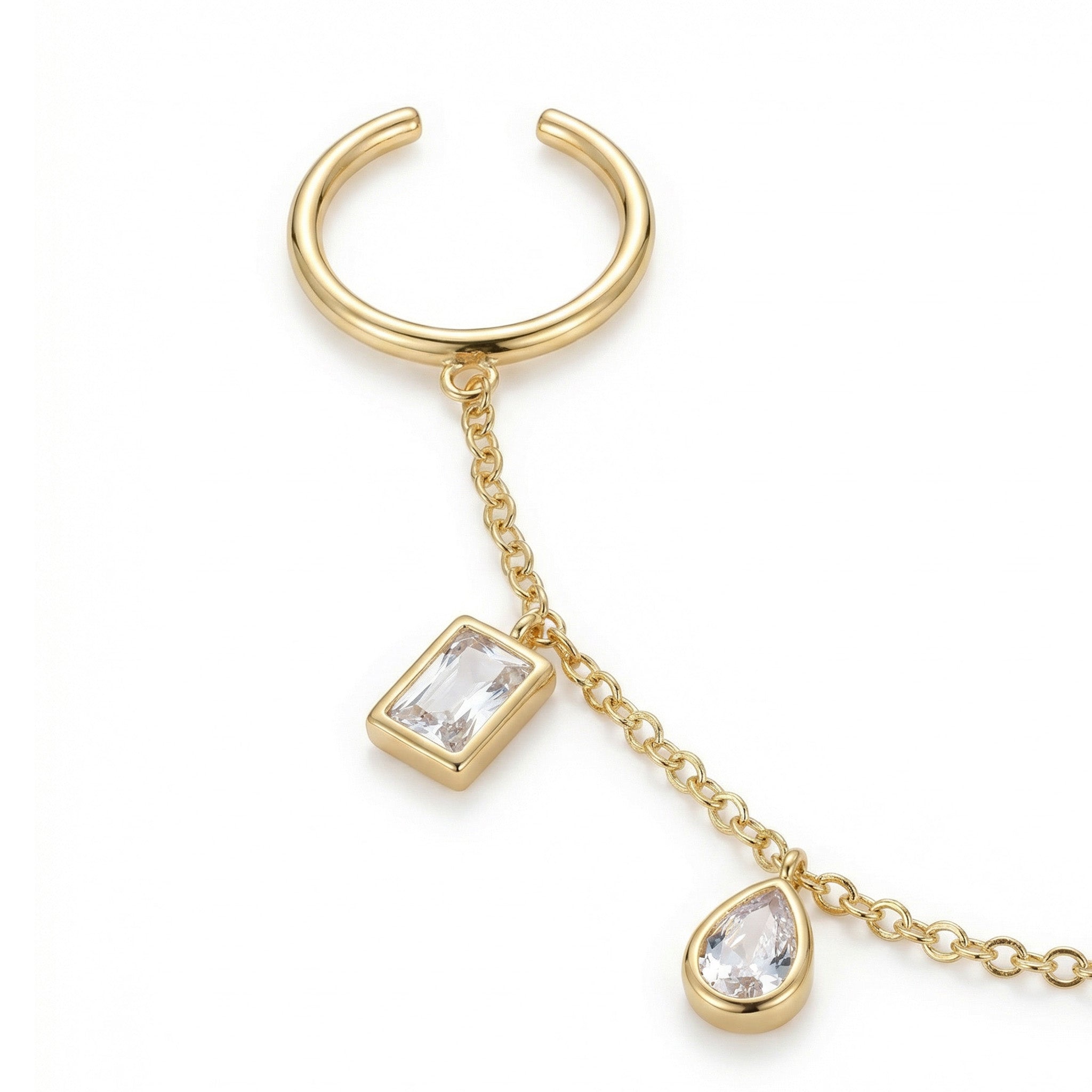 Gold ring with chain and gemstones on a white background