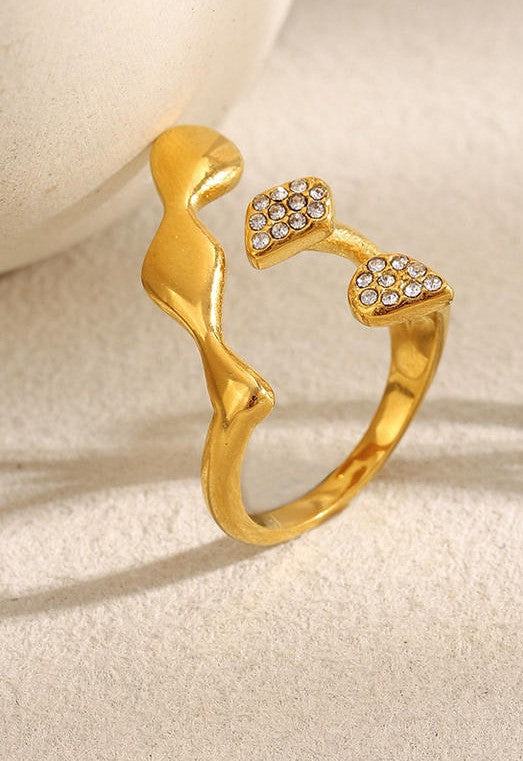Gold ring with a unique design on a beige background