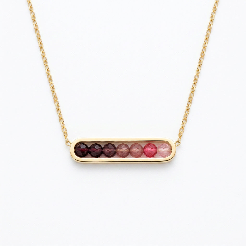 Necklace with a bar pendant featuring red and pink stones on a white background