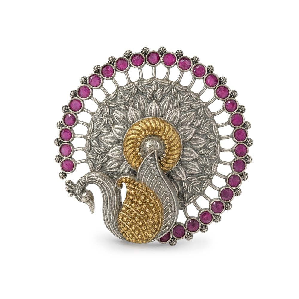 Decorative brooch with peacock design and pink gemstones on a white background