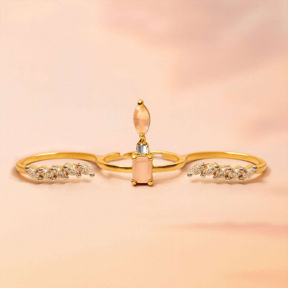 Gold ring with pink stone and diamond accents on a soft pink background