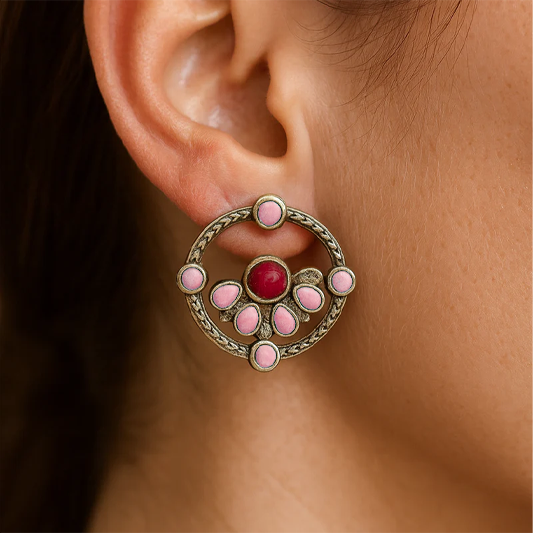 Close-up of an ear wearing a decorative earring with pink stones.