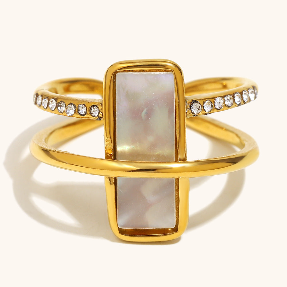 Gold ring with a central rectangular stone and diamond accents on a white background