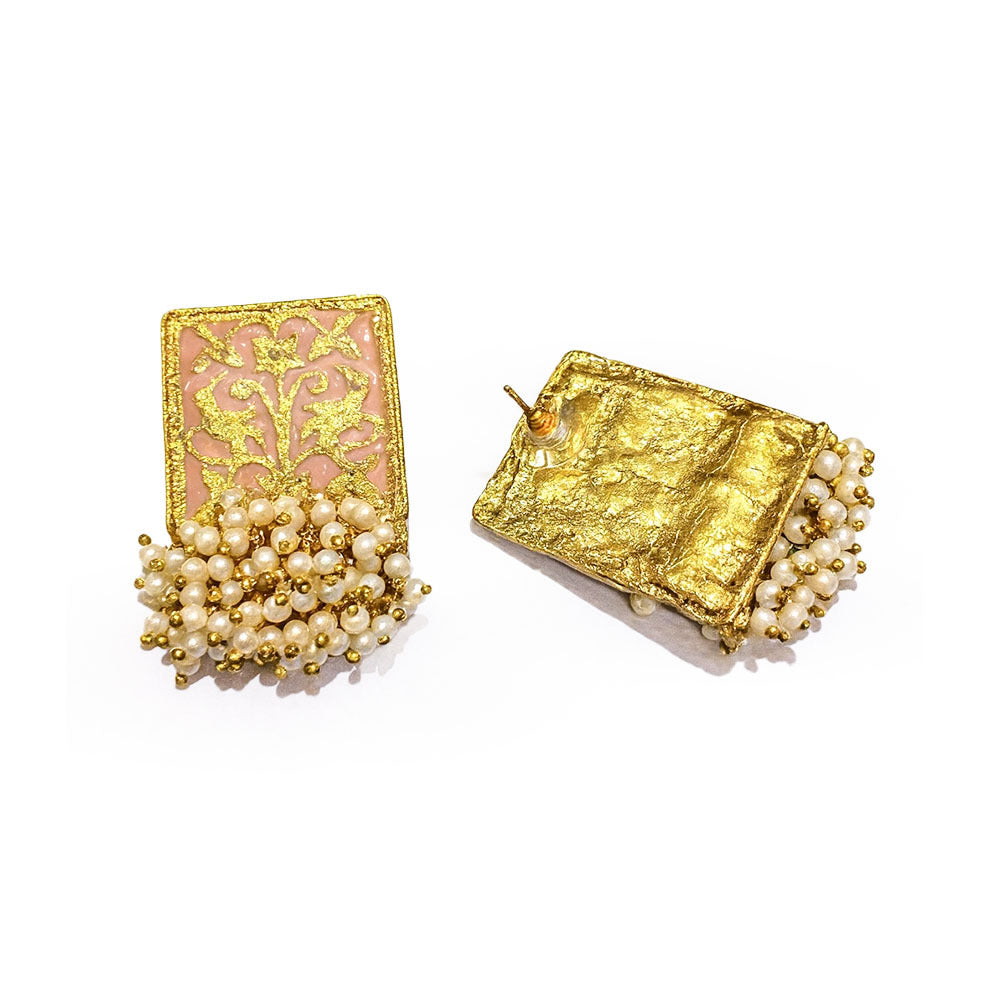 Gold earrings with pearl accents on a white background