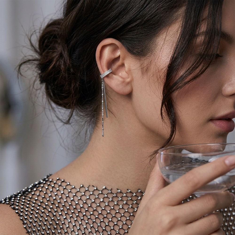 Close-up of a woman wearing a silver tassel drop earrings for women with crystal ear cuff party wear jewelry