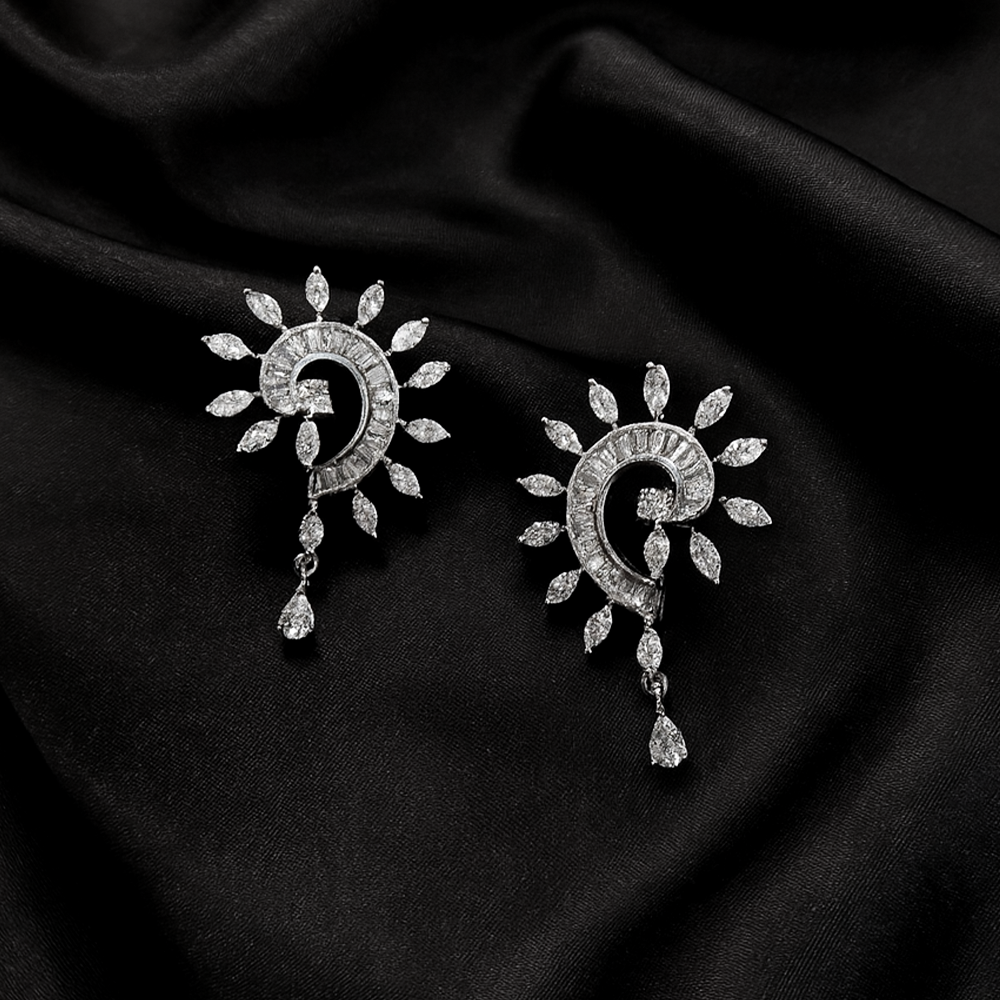Silver sun and moon earrings on a black fabric background