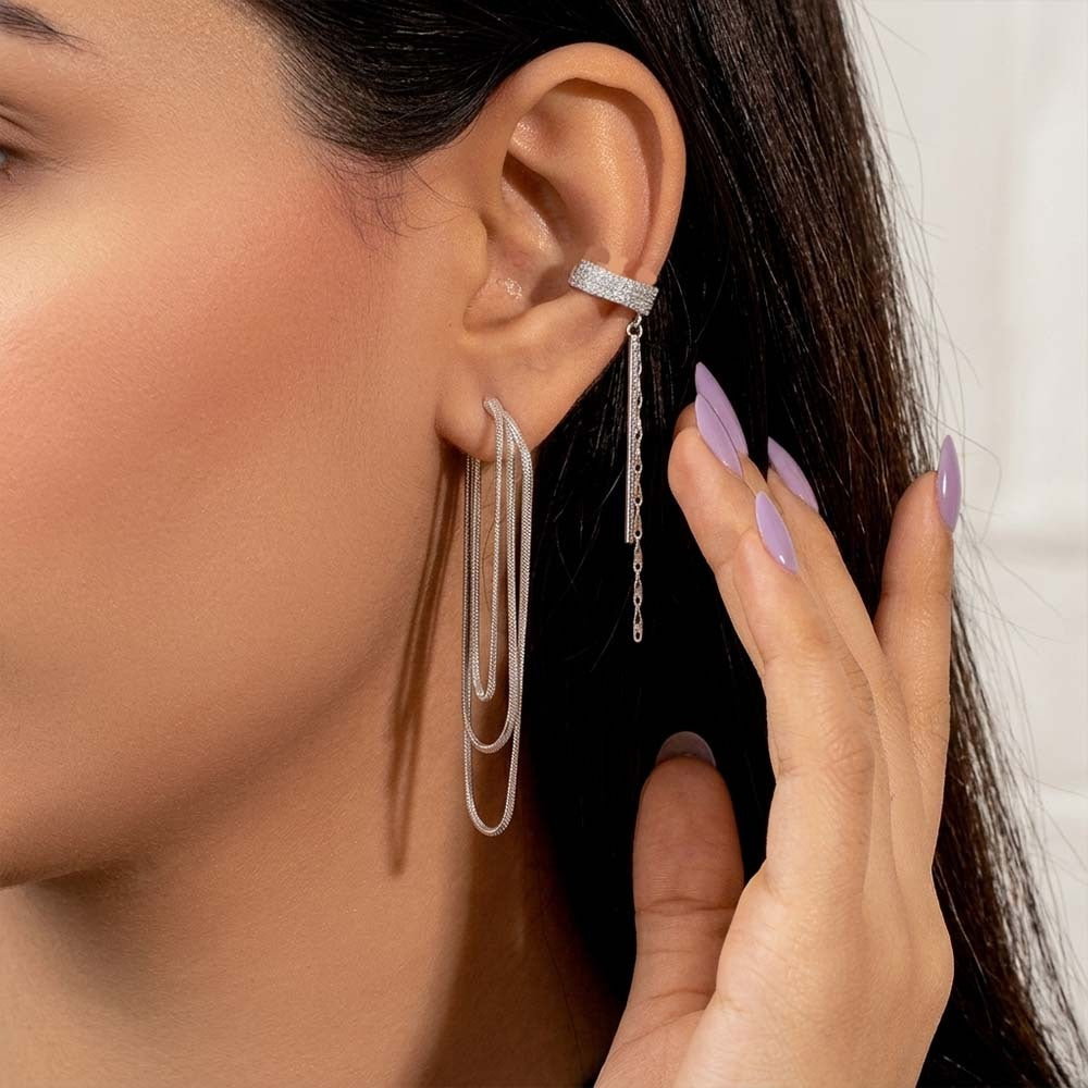 Close-up of a person wearing a silver earring with a hand adjusting it.