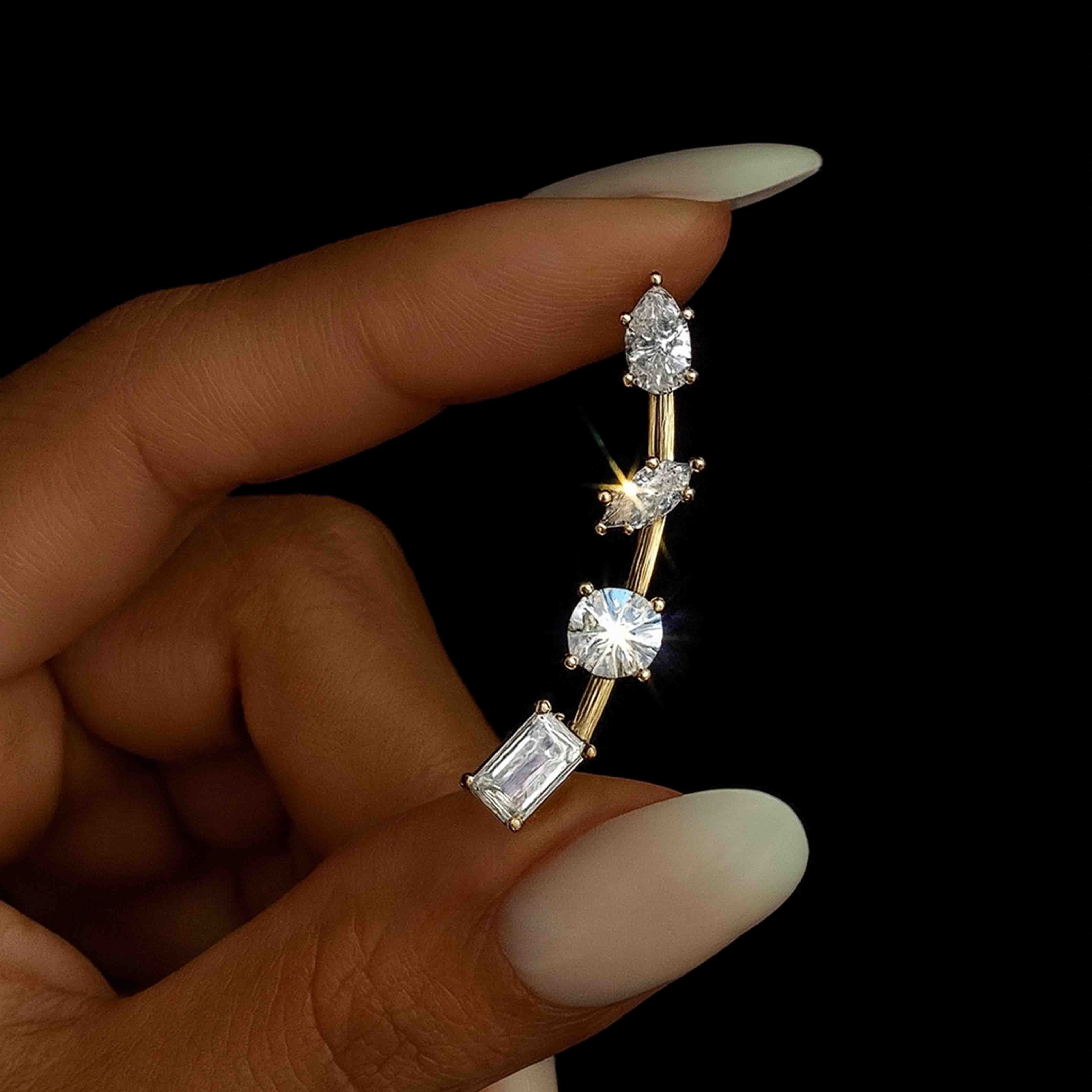 Diamond earring held between fingers against a black background