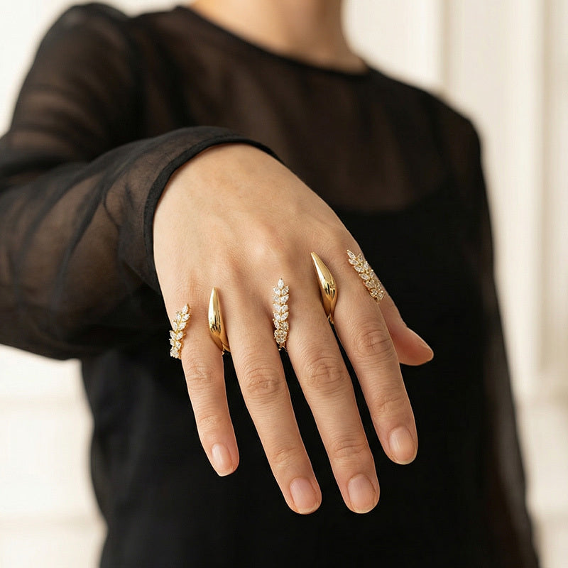 Hand wearing multiple gold rings with a blurred background