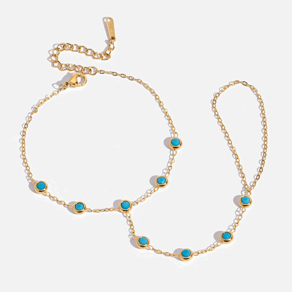 Gold necklace with turquoise stones on a white background