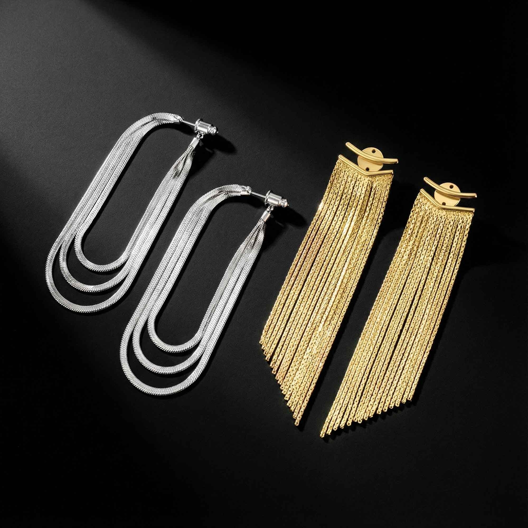 Two pairs of gold and silver earrings for women black background