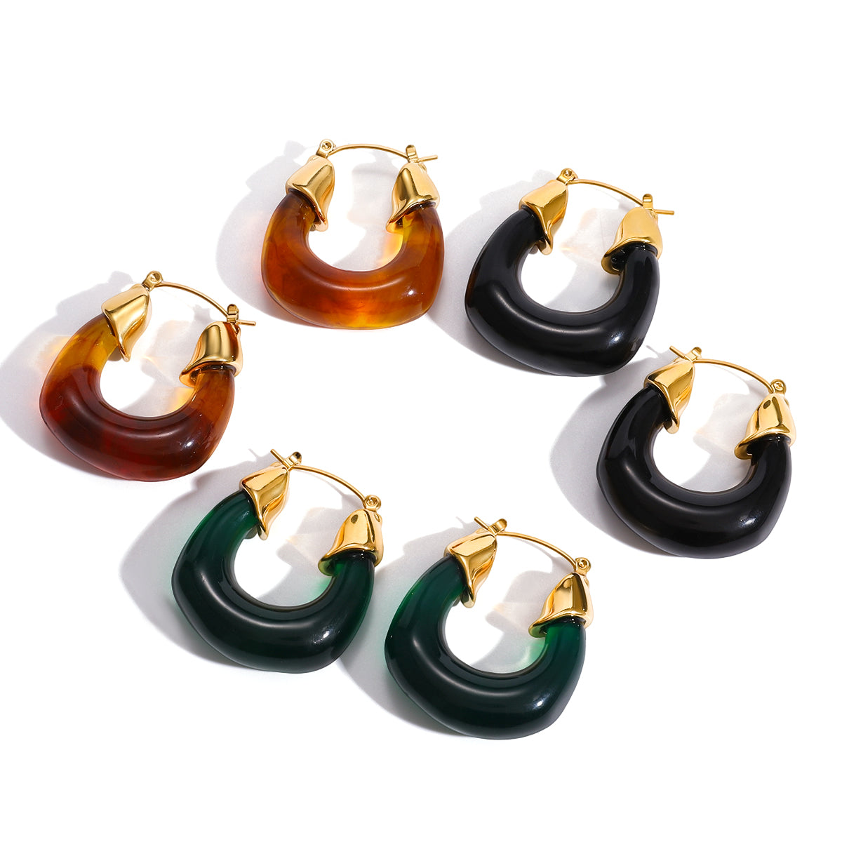 Set of hoop earrings for women in brown, black, and green with gold accents on a white background