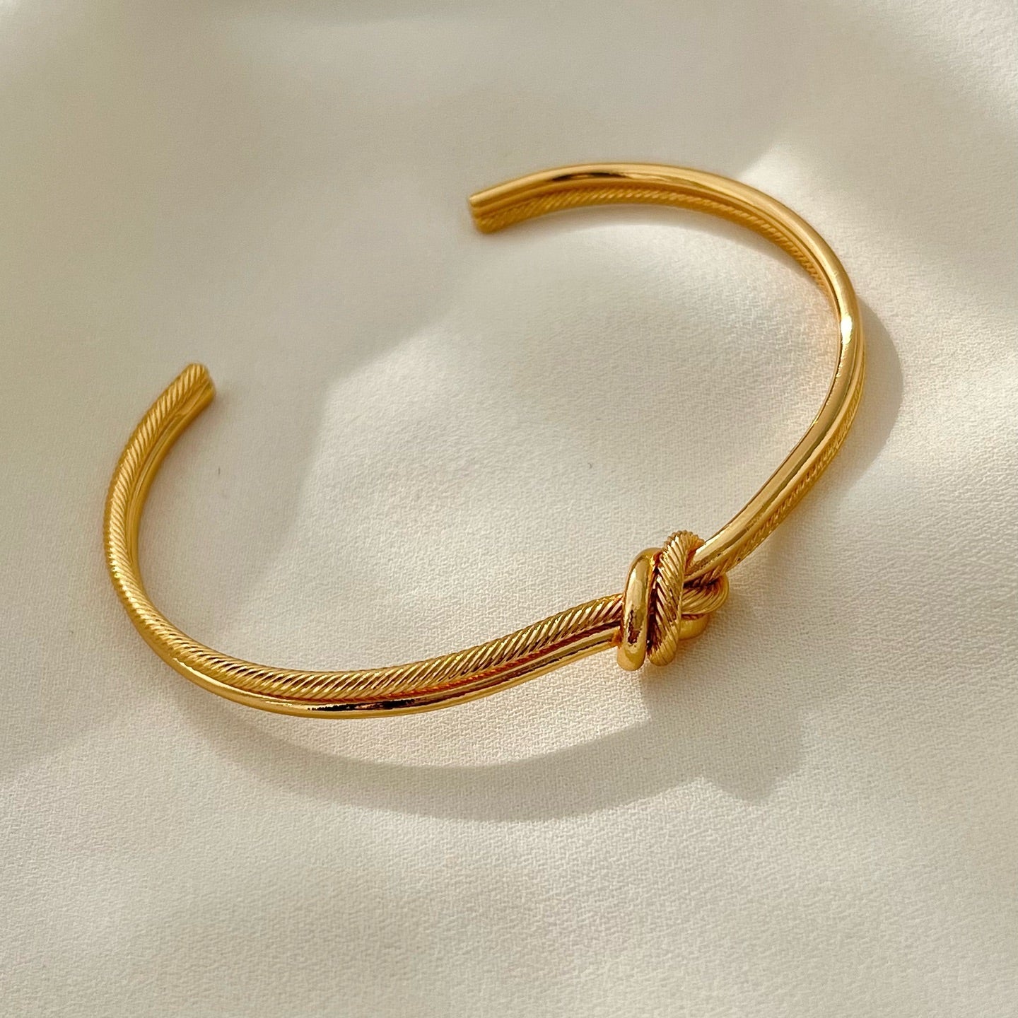Gold bracelet on a light beige background