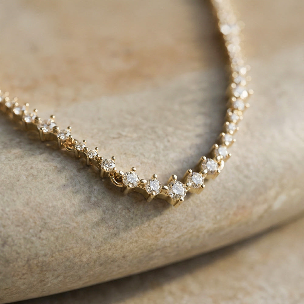 Gold necklace with diamonds on a stone surface