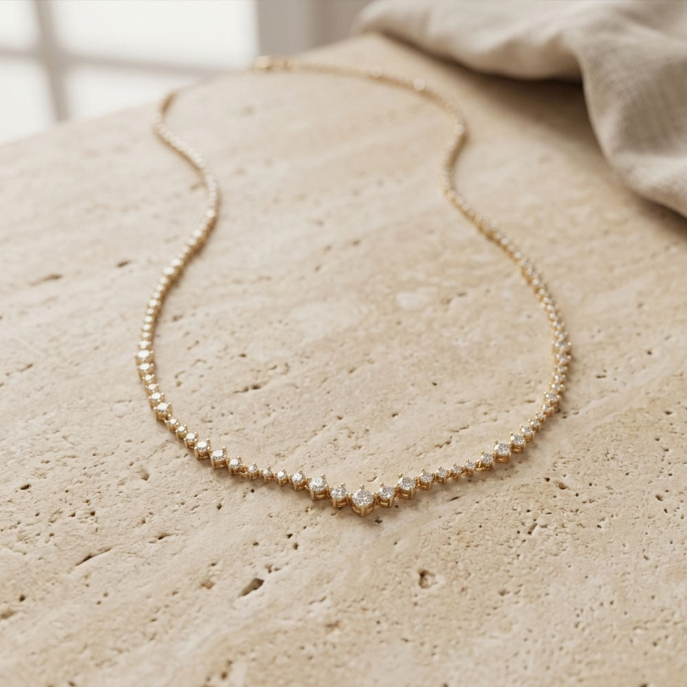 Gold necklace on a textured beige surface