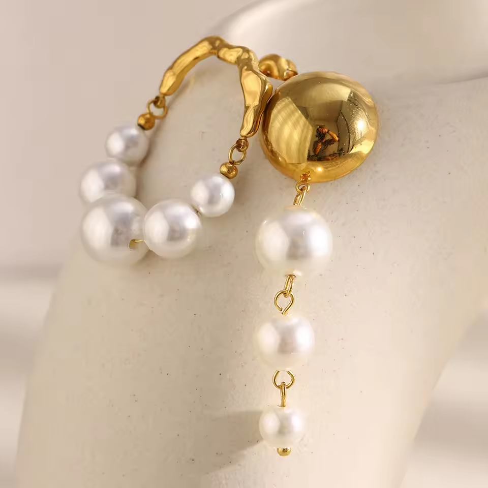 Gold and pearl earring on a mannequin ear