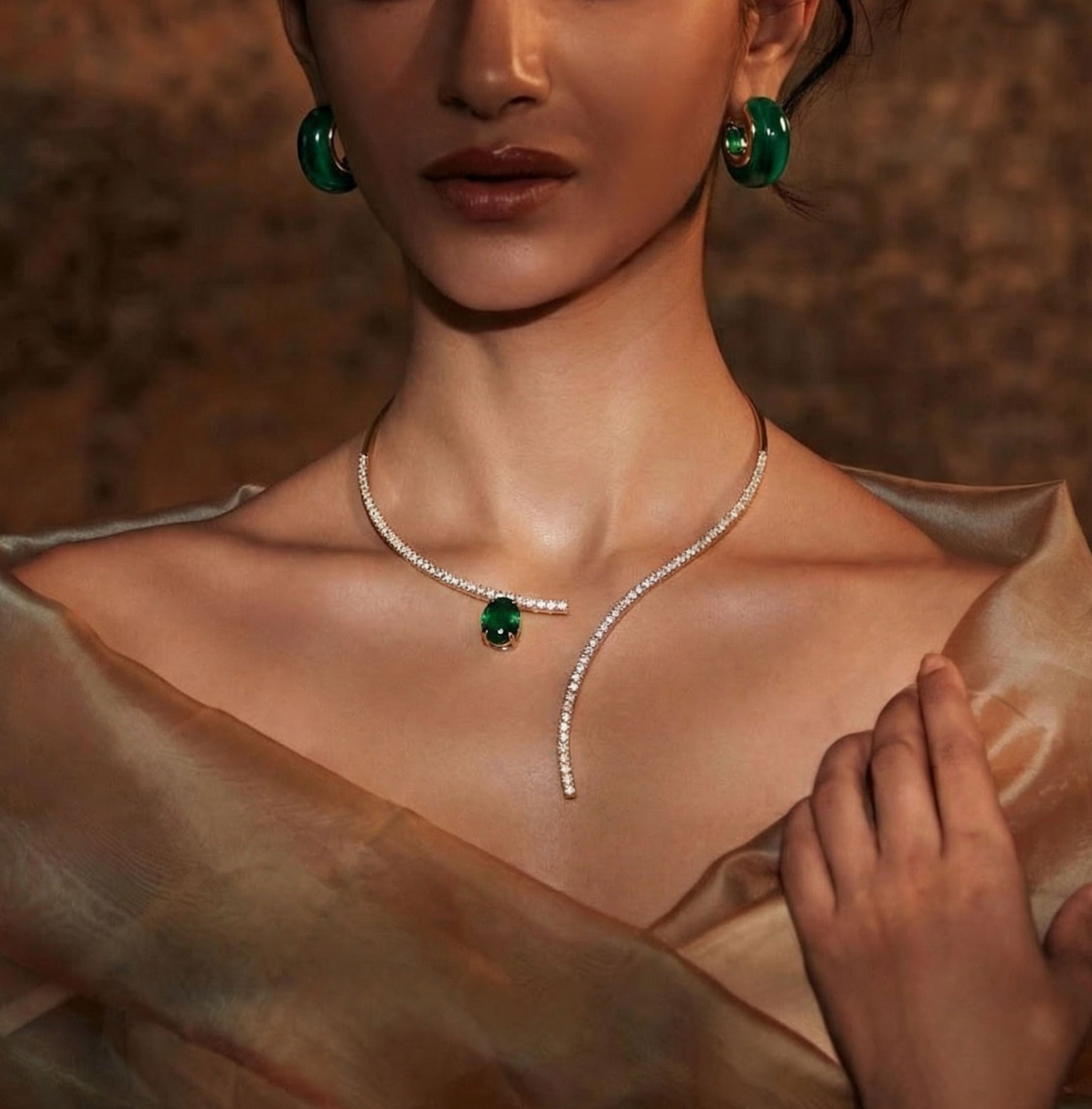 Woman wearing a necklace and earrings with a warm brown background
