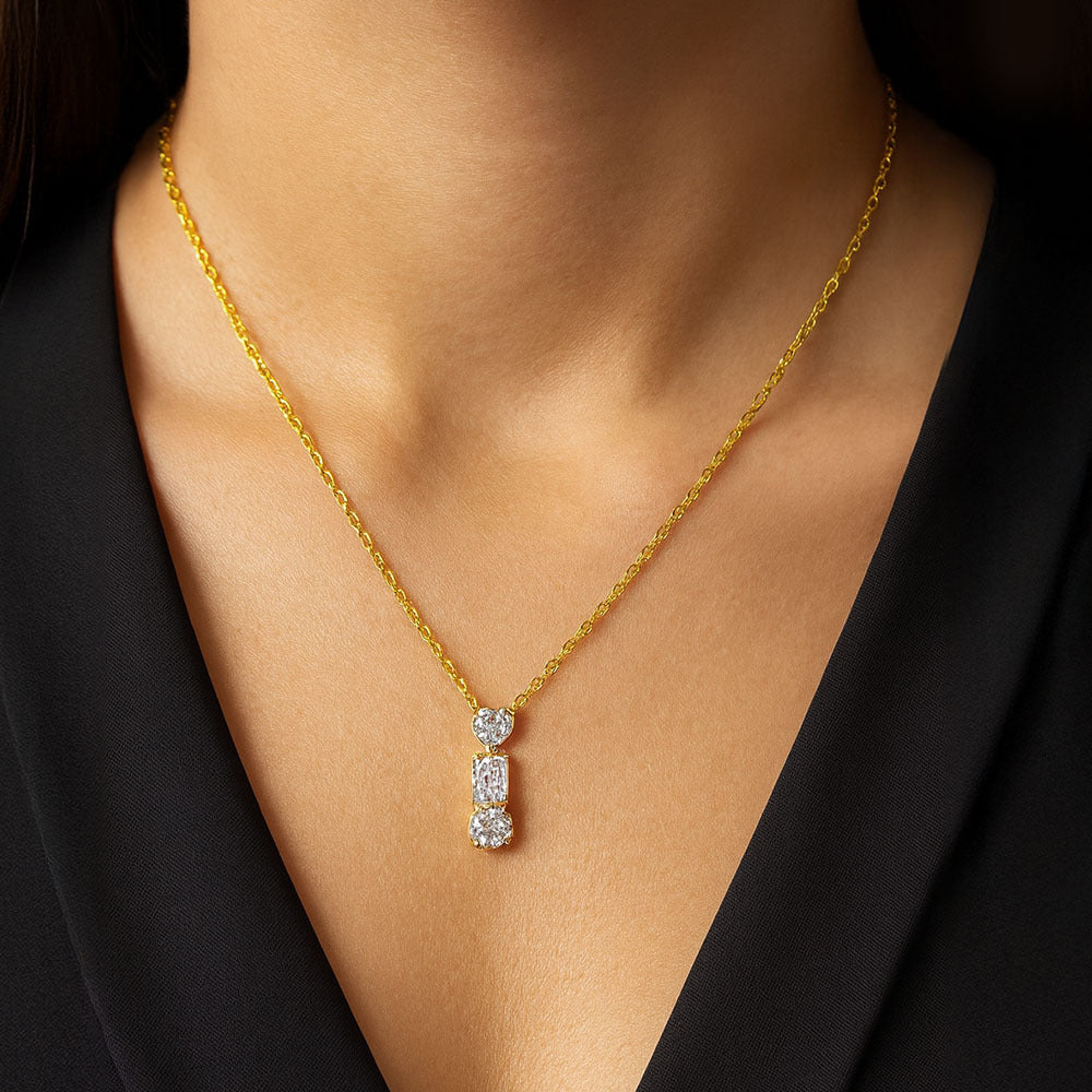 Gold necklace with a diamond pendant on a person wearing a black top.