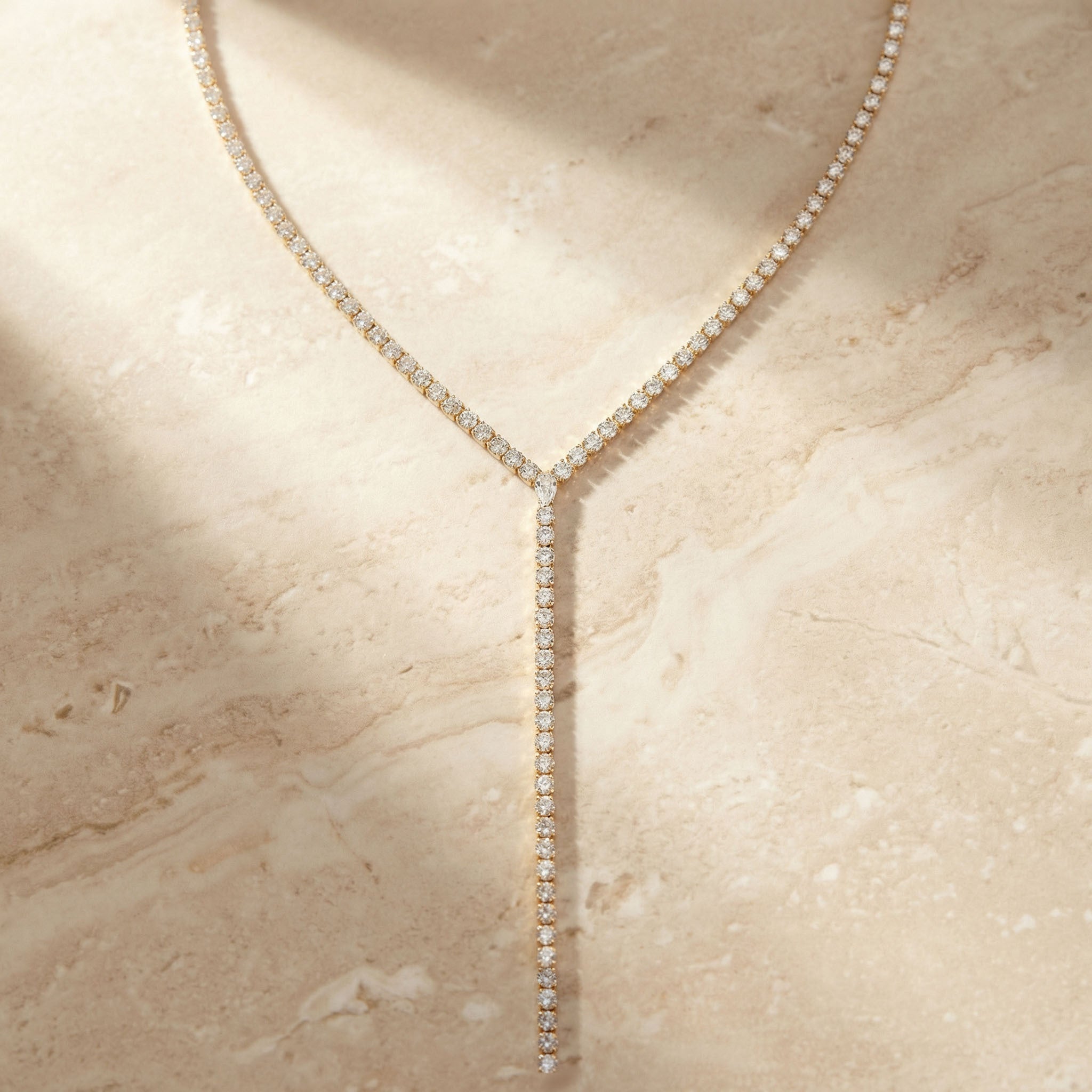 Diamond necklace on a beige marble surface