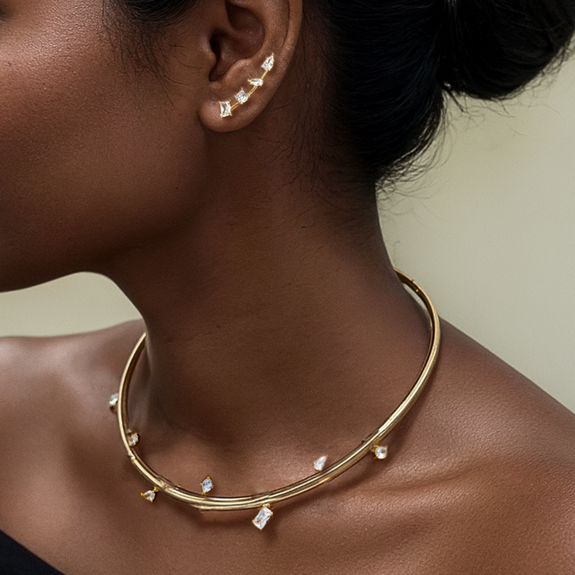 Close-up of a person wearing a gold necklace with small diamonds.