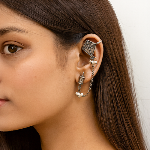 Close-up of a woman oxidised silver earring with a neutral background