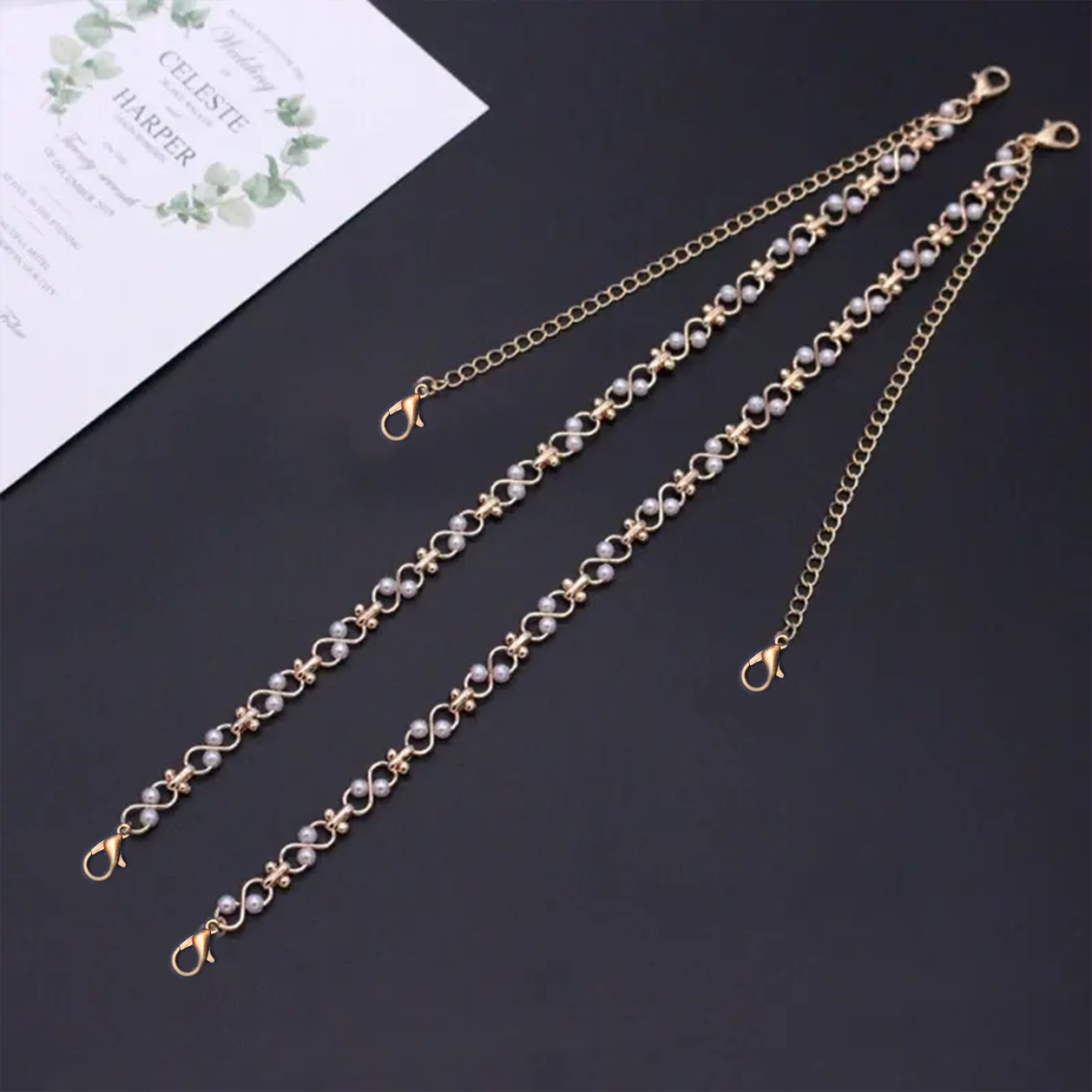 shoulder chain jewelry for women dark surface with a white card in the background.