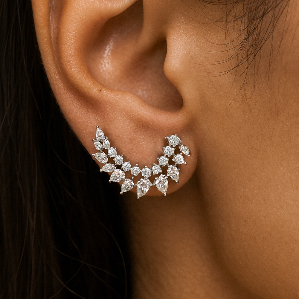 Close-up of an ear wearing a diamond earring with a dark background