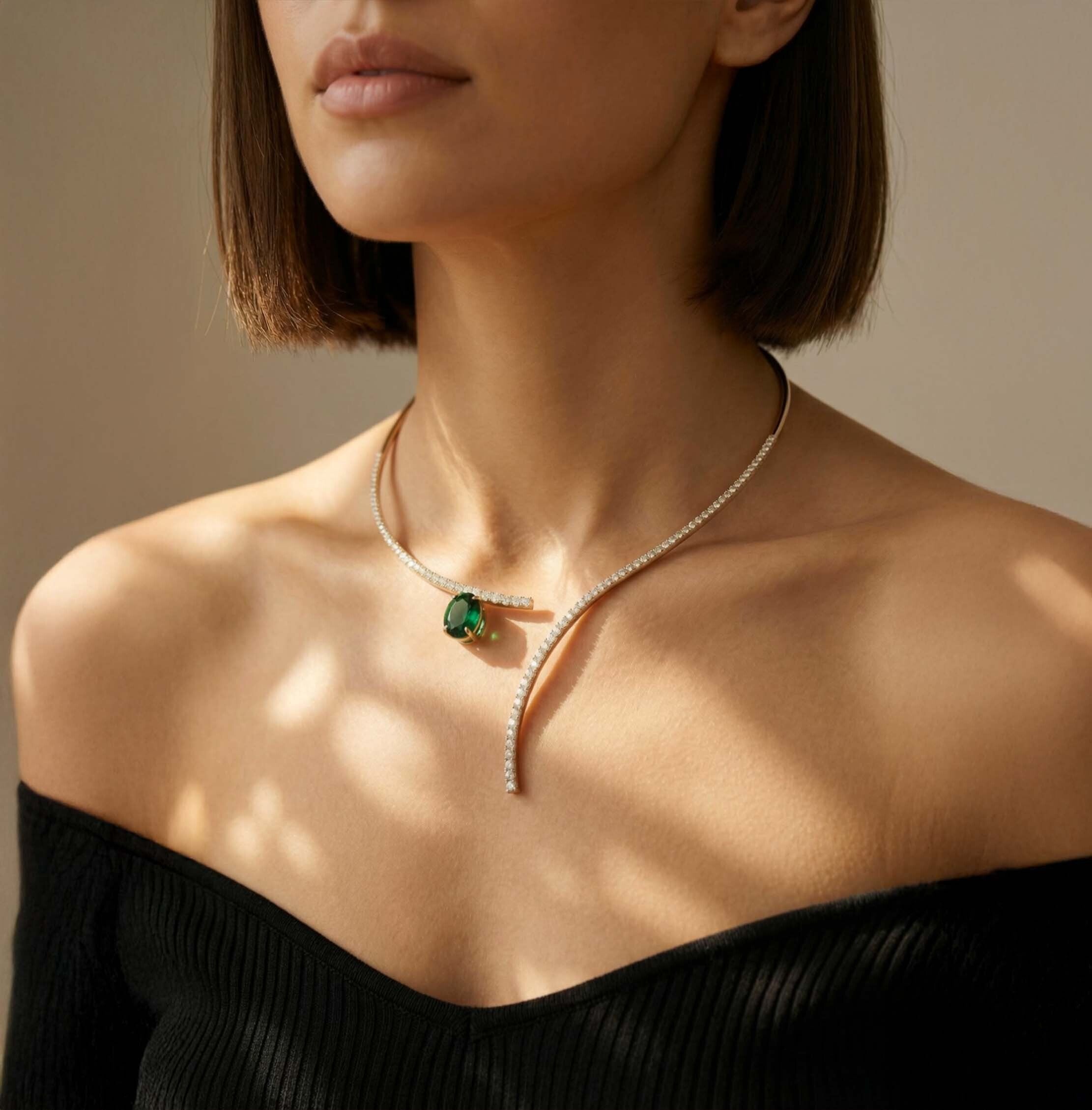 stylish gold lariat necklace for women with green gemstone modern party wear design against a neutral background