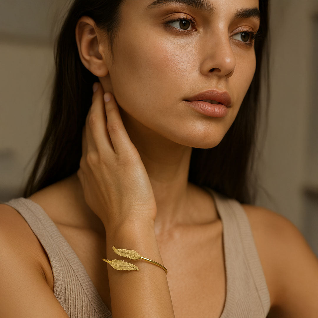 Woman wearing a gold bracelet with a neutral background