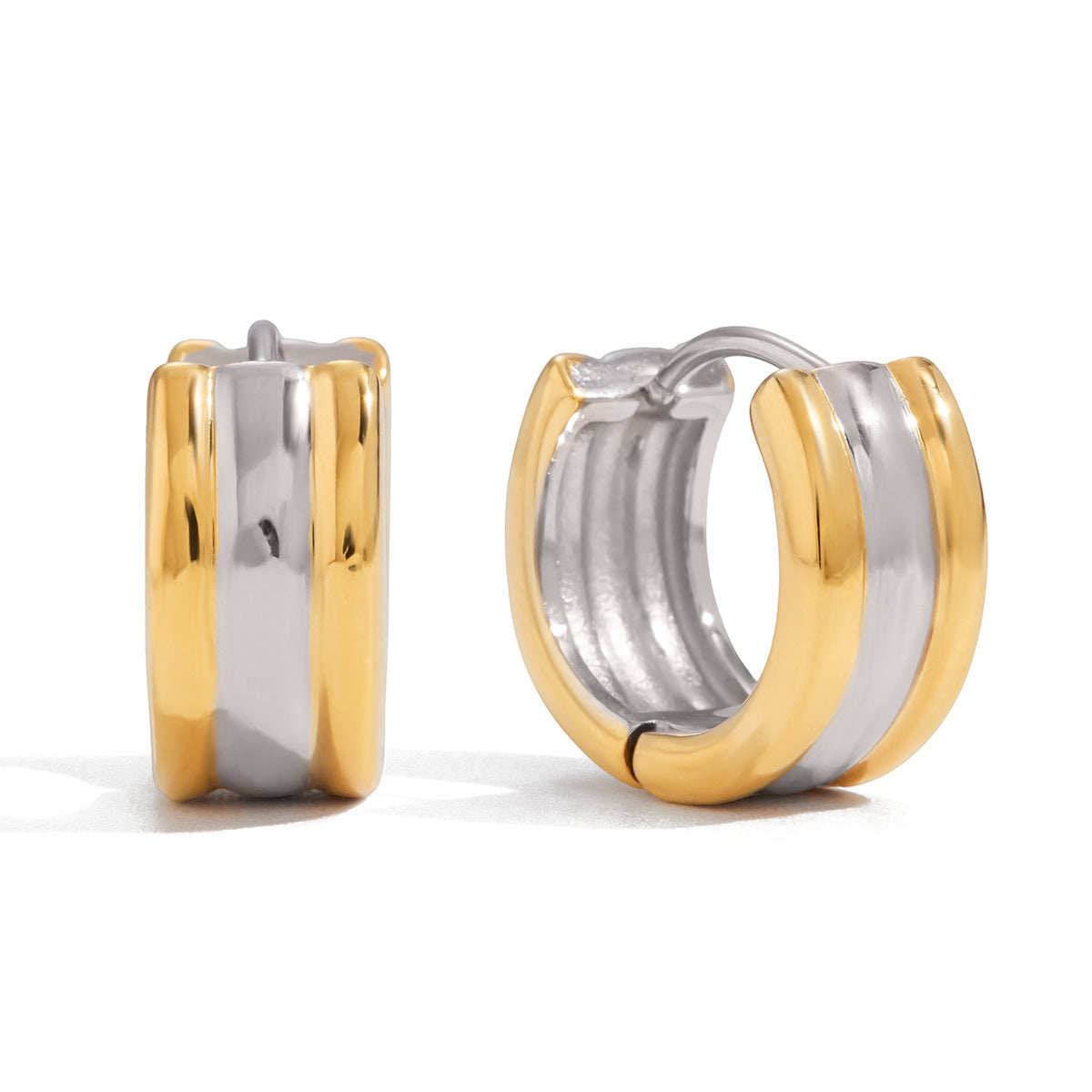 Two gold and silver hoop earrings on a white background
